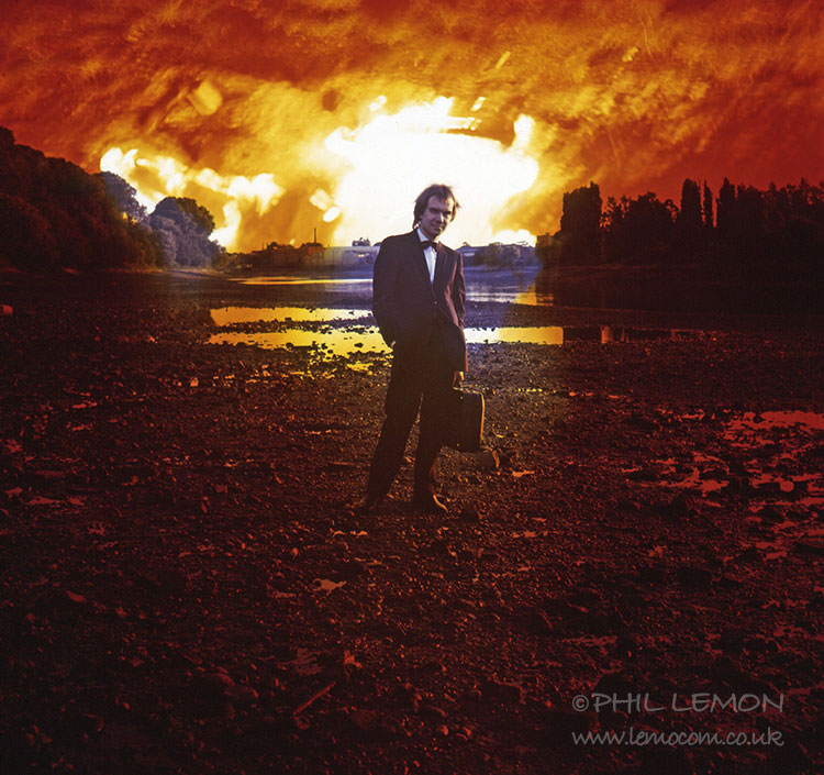 Brian Warner standing on a riverbank with the sky in flames, Phil Lemon
